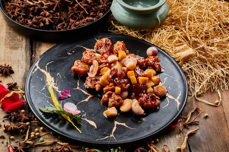 陈旧木板上的黑石盘装的土豆小洋葱炸里脊图片