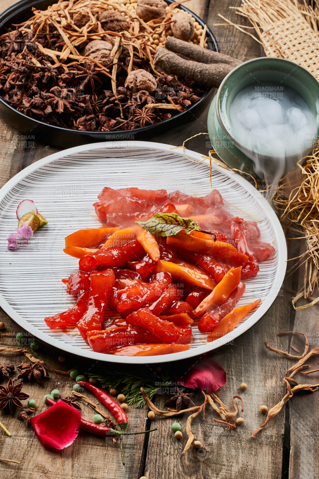 陈旧木板上的条纹圆瓷盘装的红烧蹄筋图片