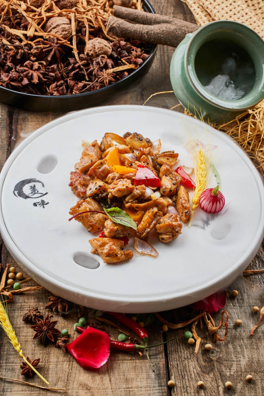 陈旧木板上的白瓷圆盘装的黑椒鲜鲍鱼烧鸡块图片