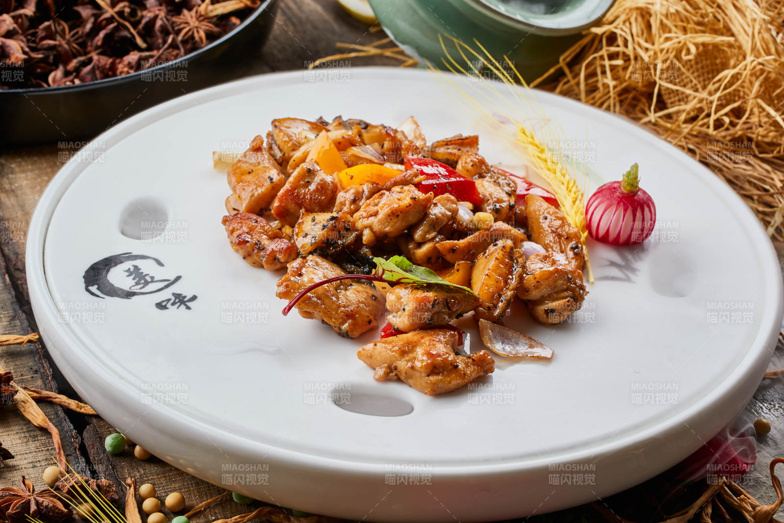 陈旧木板上的白瓷圆盘装的黑椒鲜鲍鱼烧鸡块图片