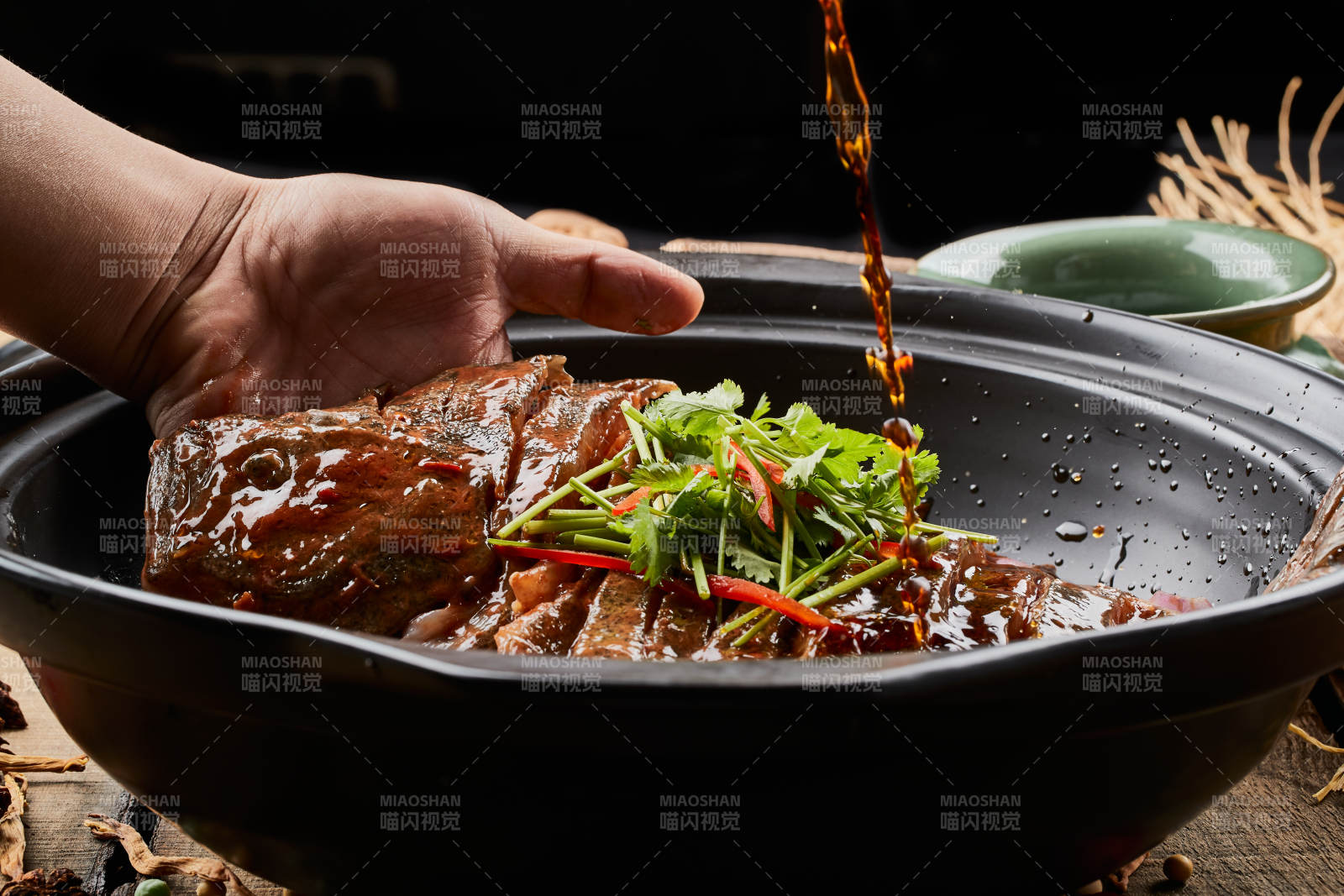 陈旧木板上的黑色砂锅装的浓汤生噘鲽鱼图片