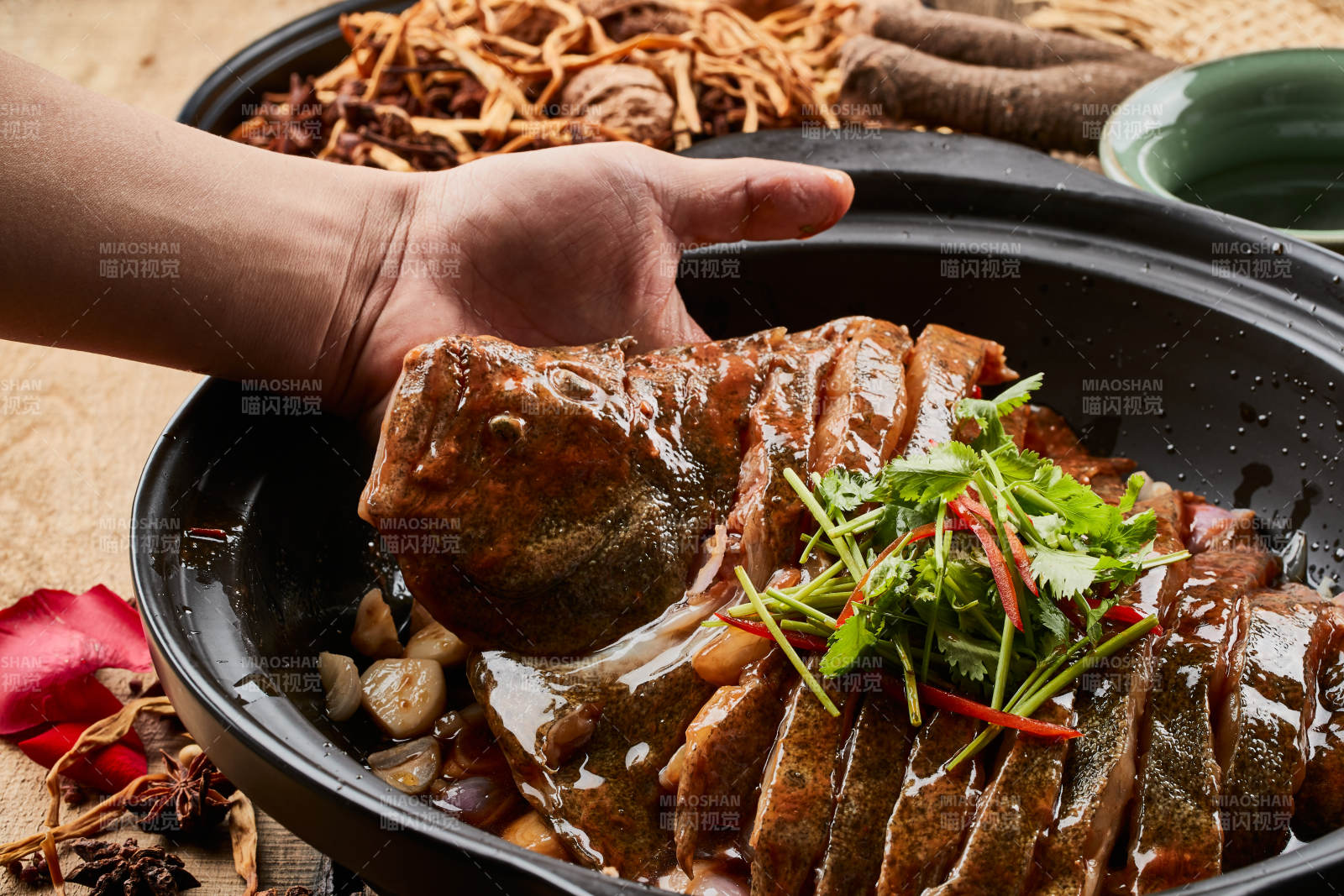 陈旧木板上的黑色砂锅装的浓汤生噘鲽鱼图片