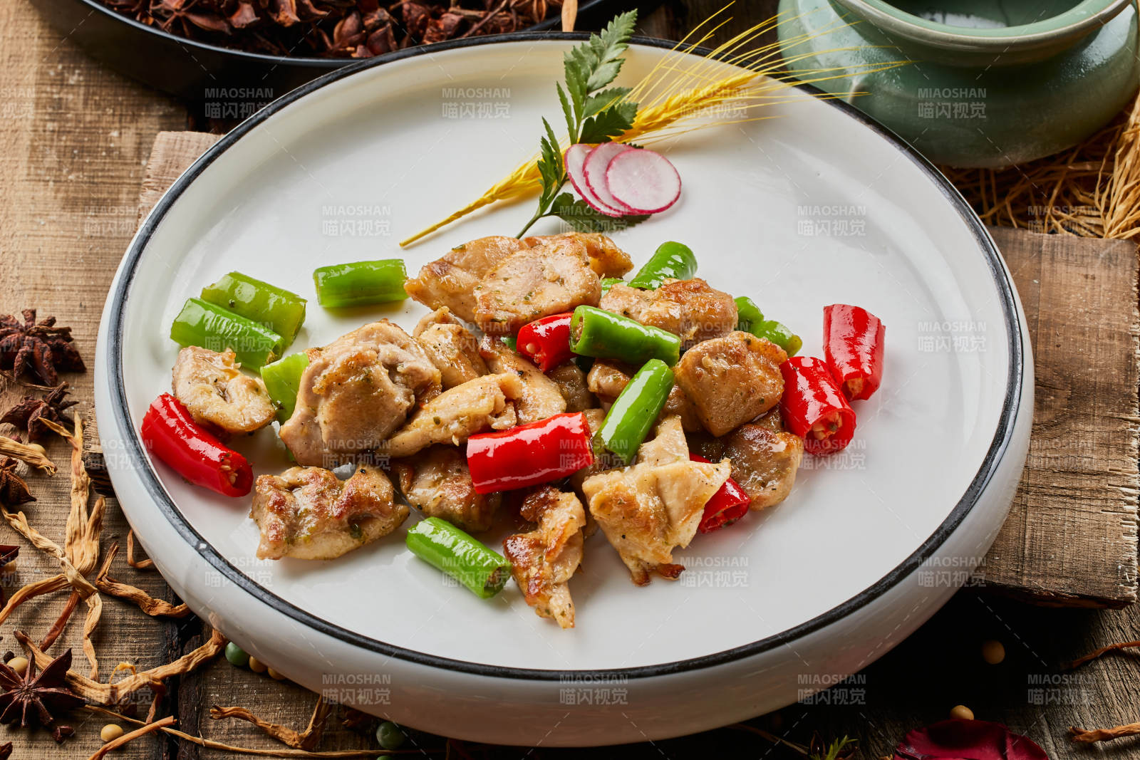 陈旧木板上的白色圆瓷盘装的杭椒鸡排图片