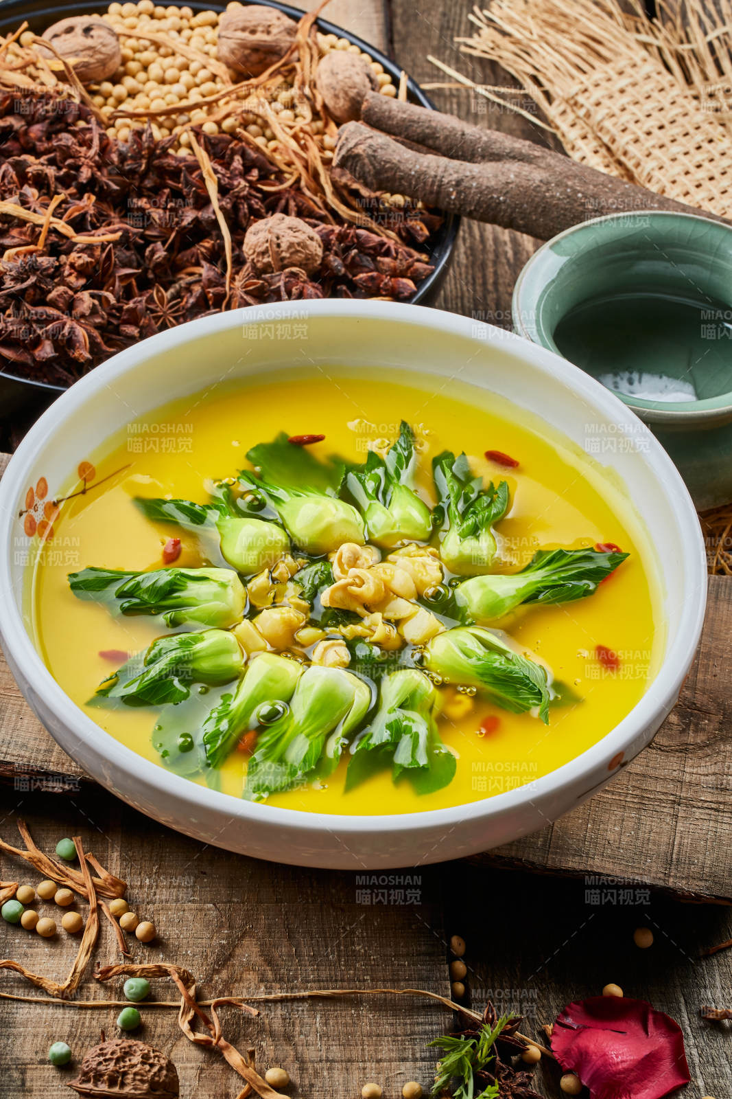 陈旧木板上的白瓷圆盘装的浓汤油菜烧菇片图片