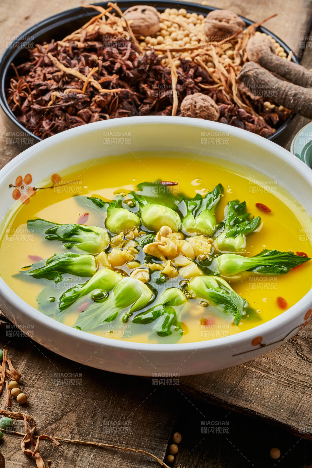 陈旧木板上的白瓷圆盘装的浓汤油菜烧菇片图片