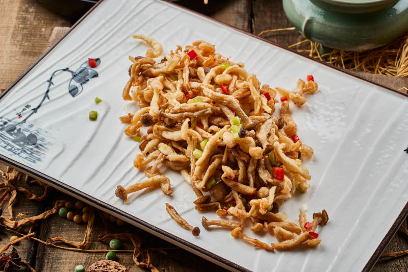 陈旧木板上的方瓷盘装的香炸鲜蘑图片