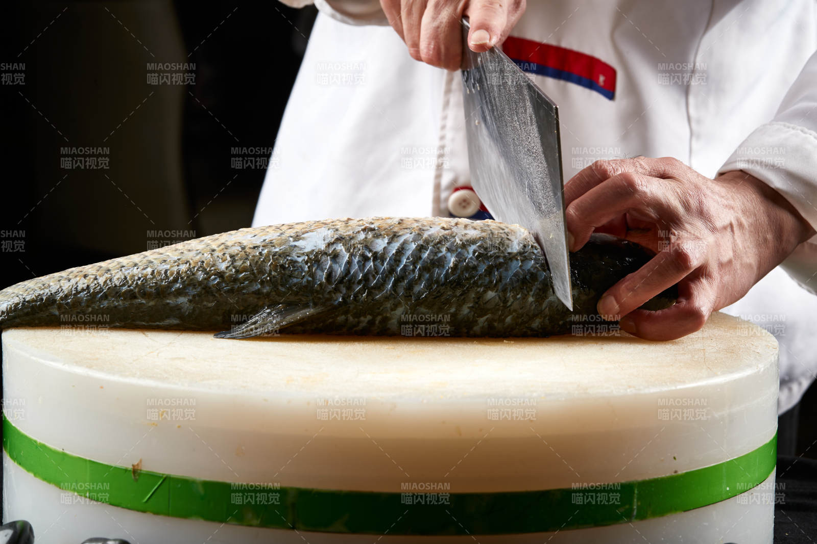 白色砧板上厨师用精湛的刀工展示生鱼片及鲜鱼料理切割分切的刀工图片