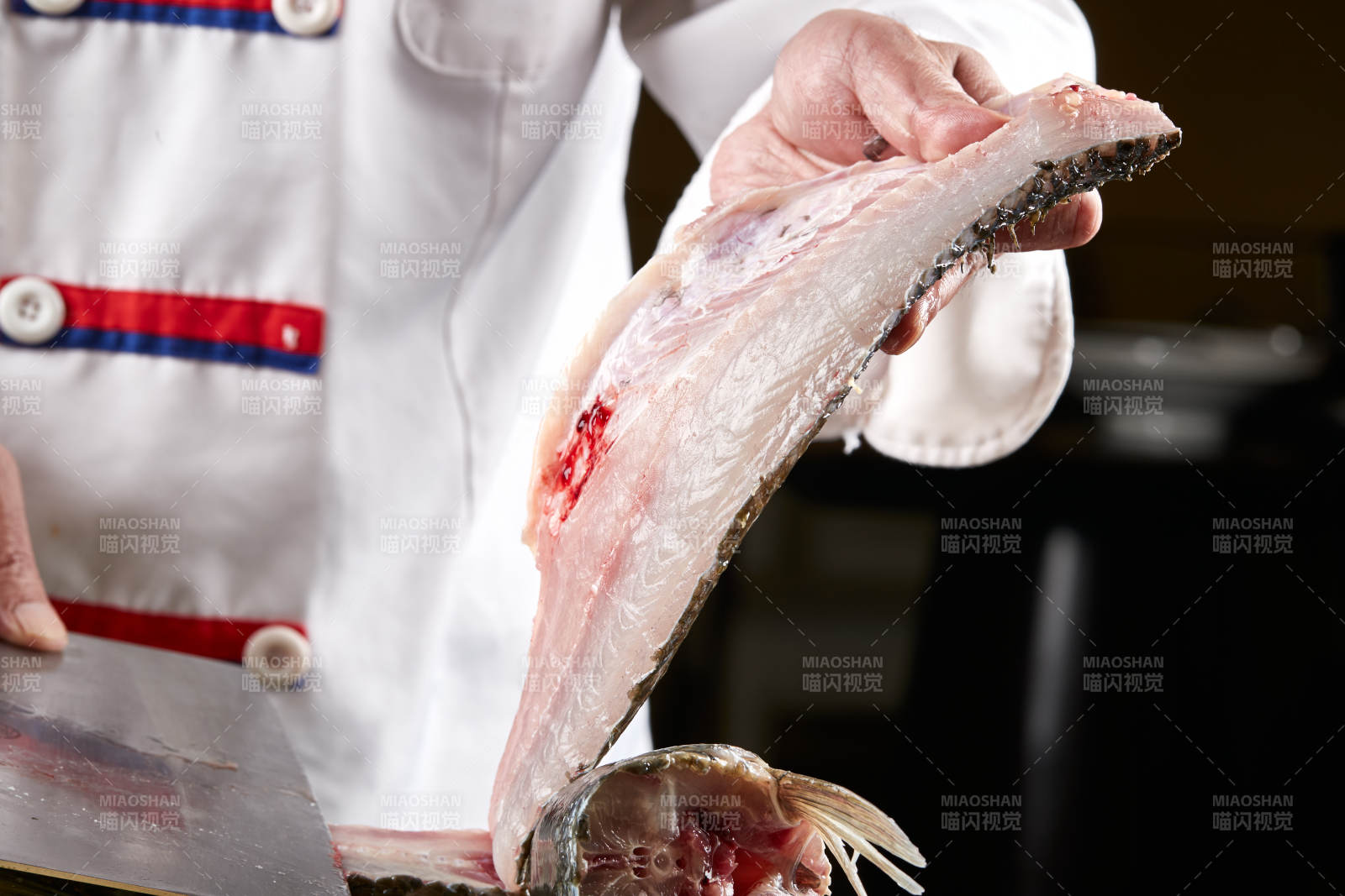 白色砧板上厨师用精湛的刀工展示生鱼片及鲜鱼料理切割分切的刀工图片