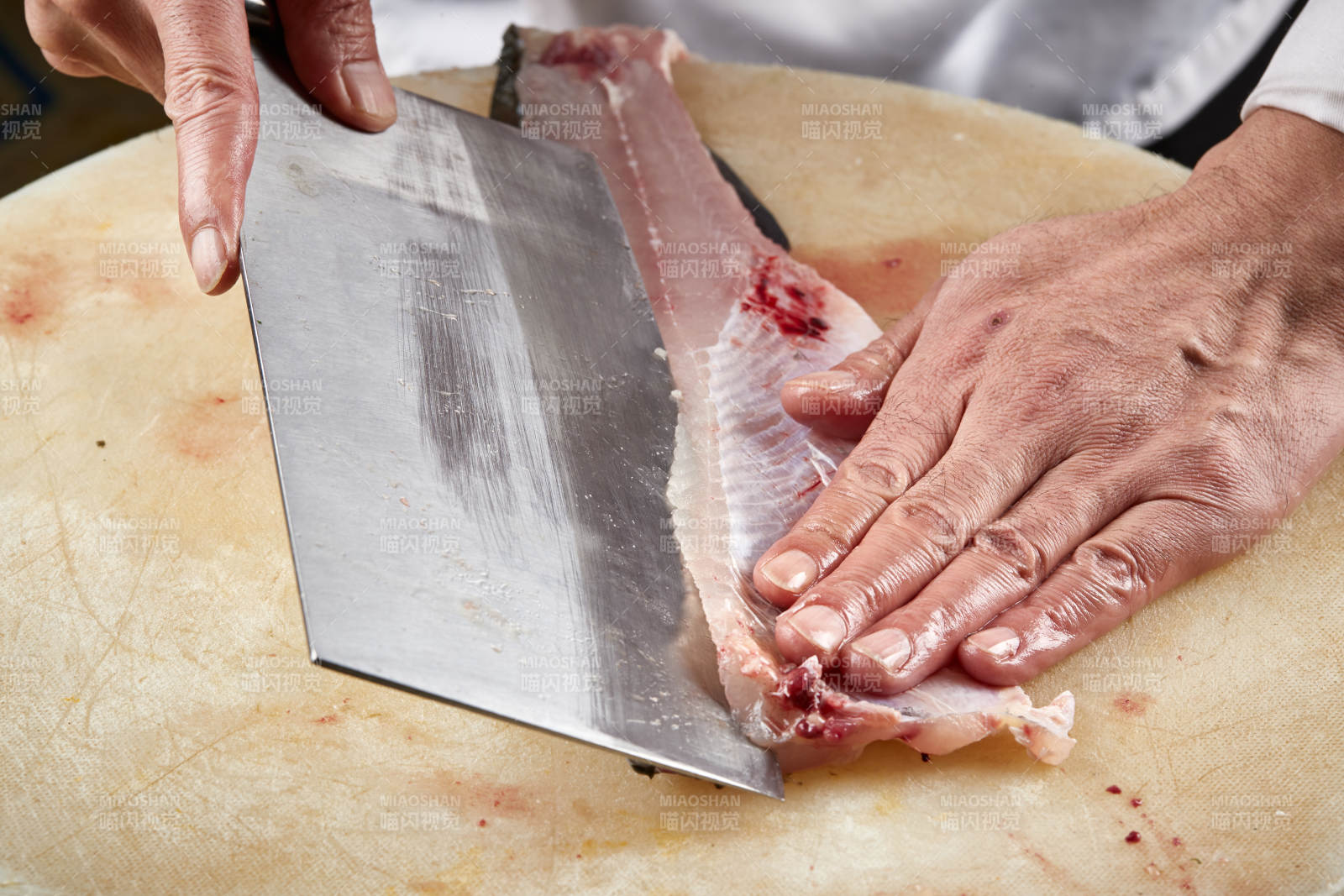 白色砧板上厨师用精湛的刀工展示生鱼片及鲜鱼料理切割分切的刀工图片