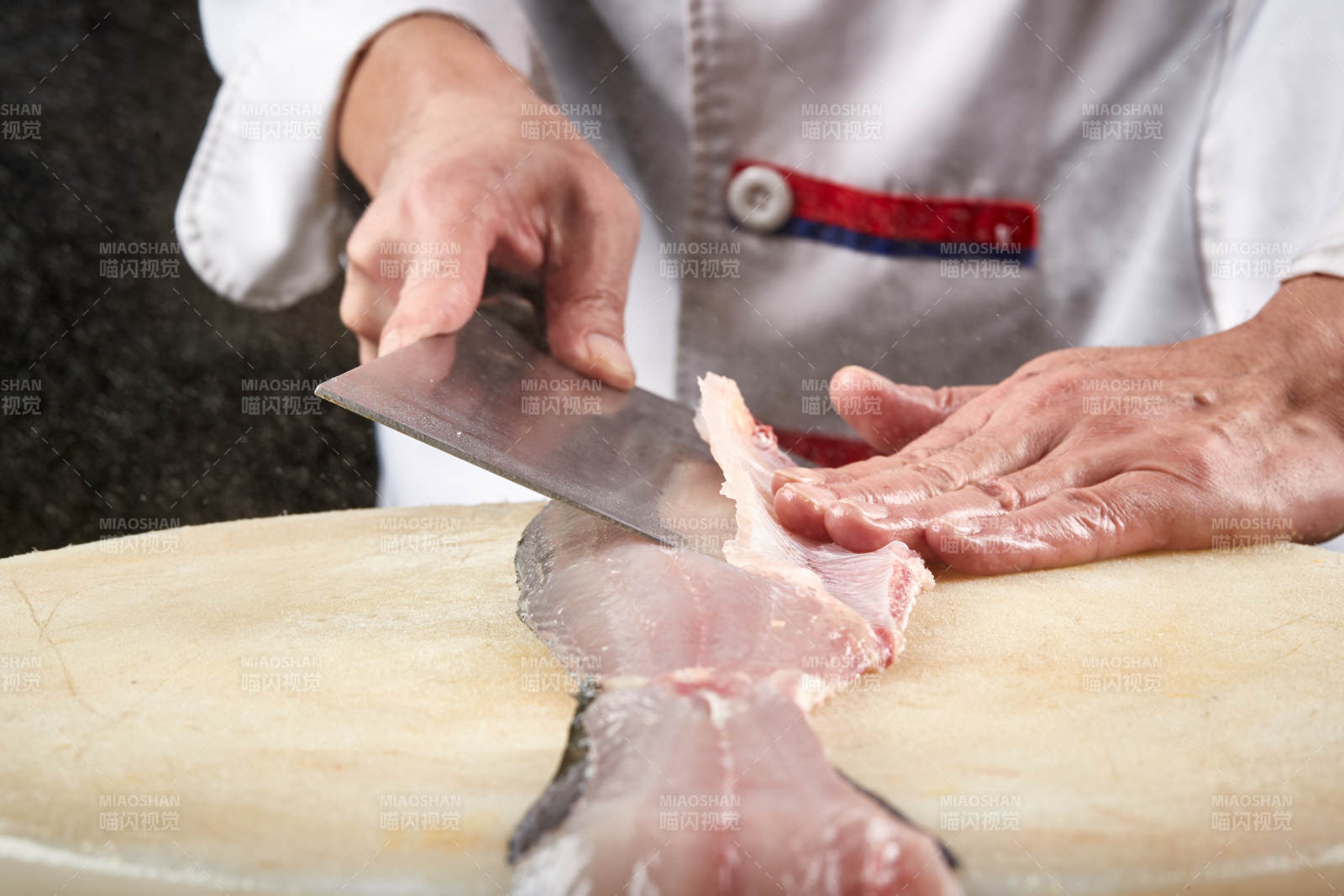 白色砧板上厨师用精湛的刀工展示生鱼片及鲜鱼料理切割分切的刀工图片