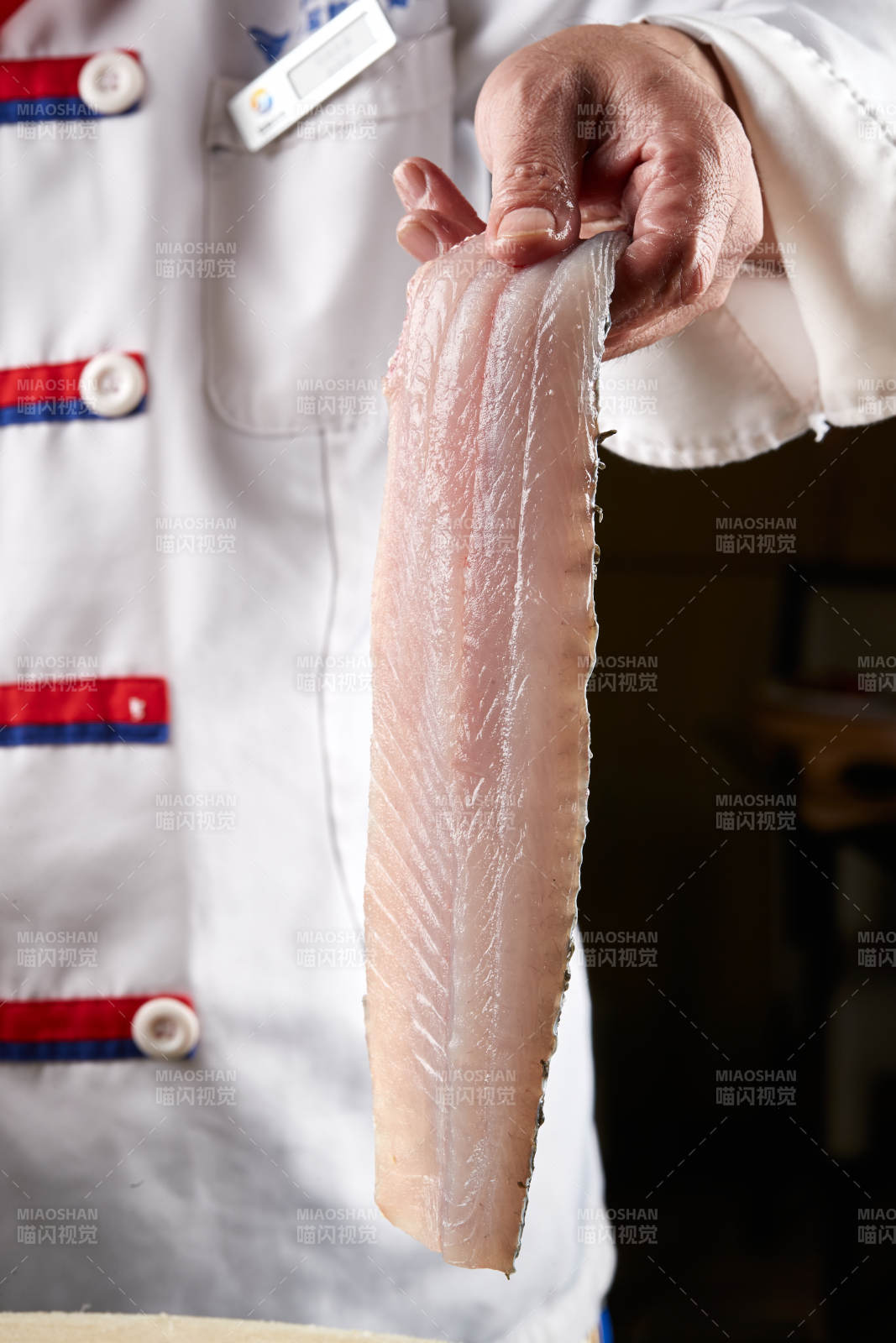 白色砧板上厨师用精湛的刀工展示生鱼片及鲜鱼料理切割分切的刀工图片