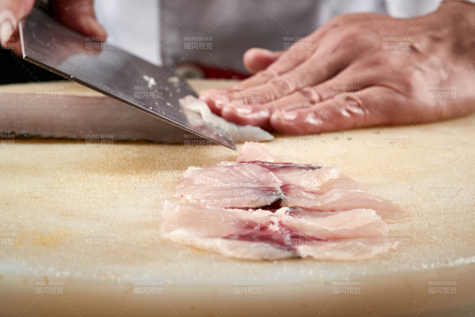 白色砧板上厨师用精湛的刀工展示生鱼片及鲜鱼料理切割分切的刀工图片