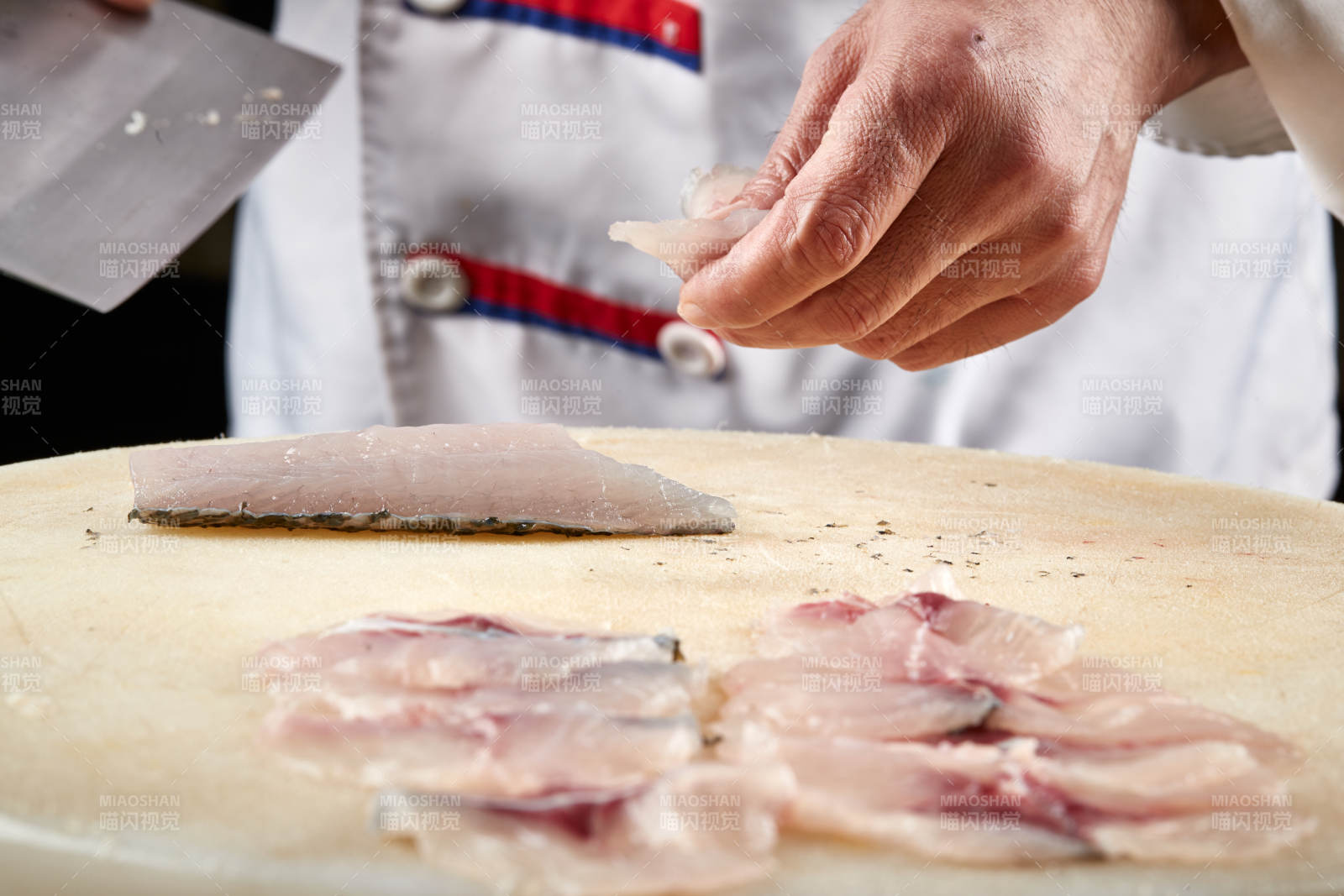 白色砧板上厨师用精湛的刀工展示生鱼片及鲜鱼料理切割分切的刀工图片