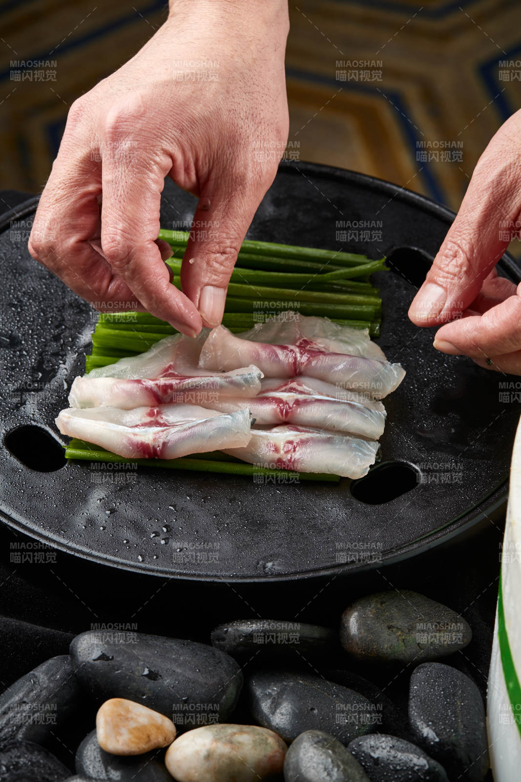 将晶莹白润的鲜鱼片码放在黑色的圆瓷盘上图片