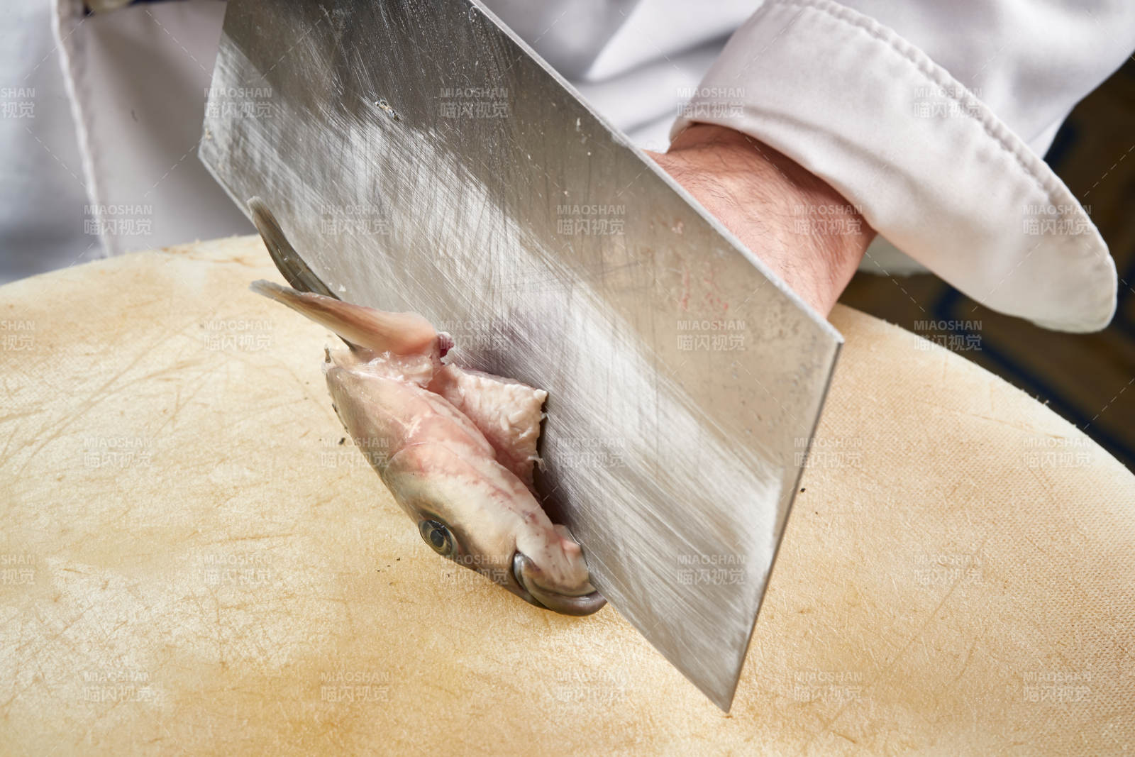 白色砧板上厨师用精湛的刀工展示生鱼片及鲜鱼料理切割分切的刀工图片