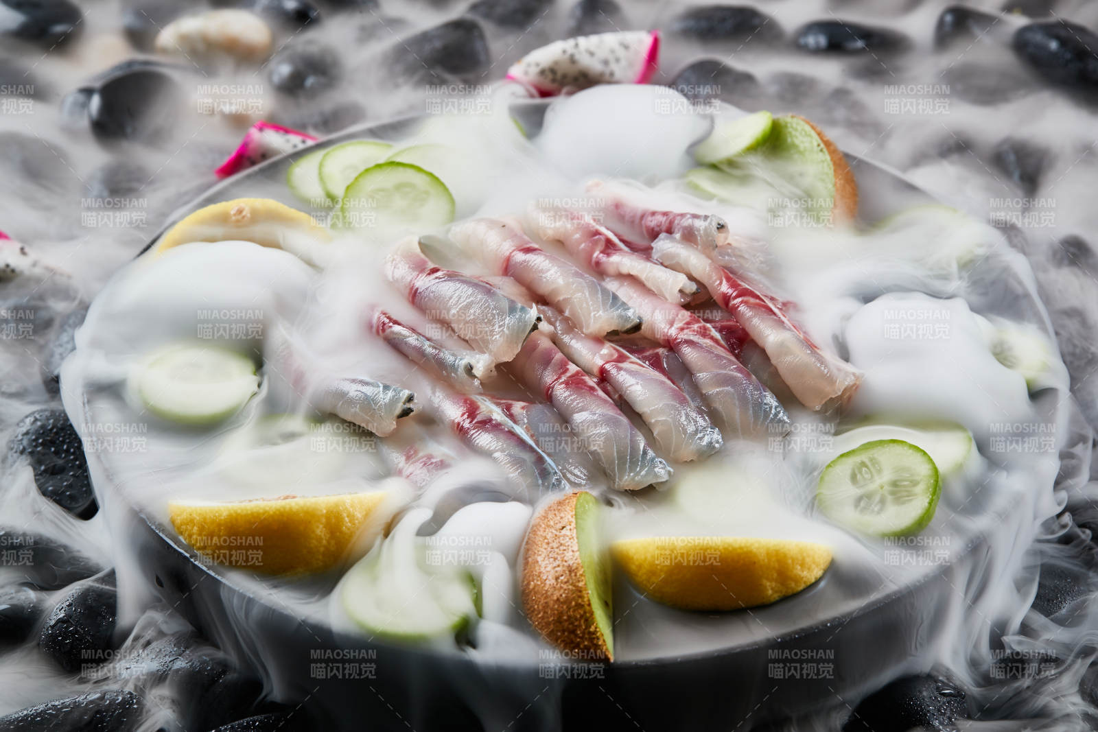 将晶莹白润的鲜鱼片码放在黑色的圆瓷盘上图片