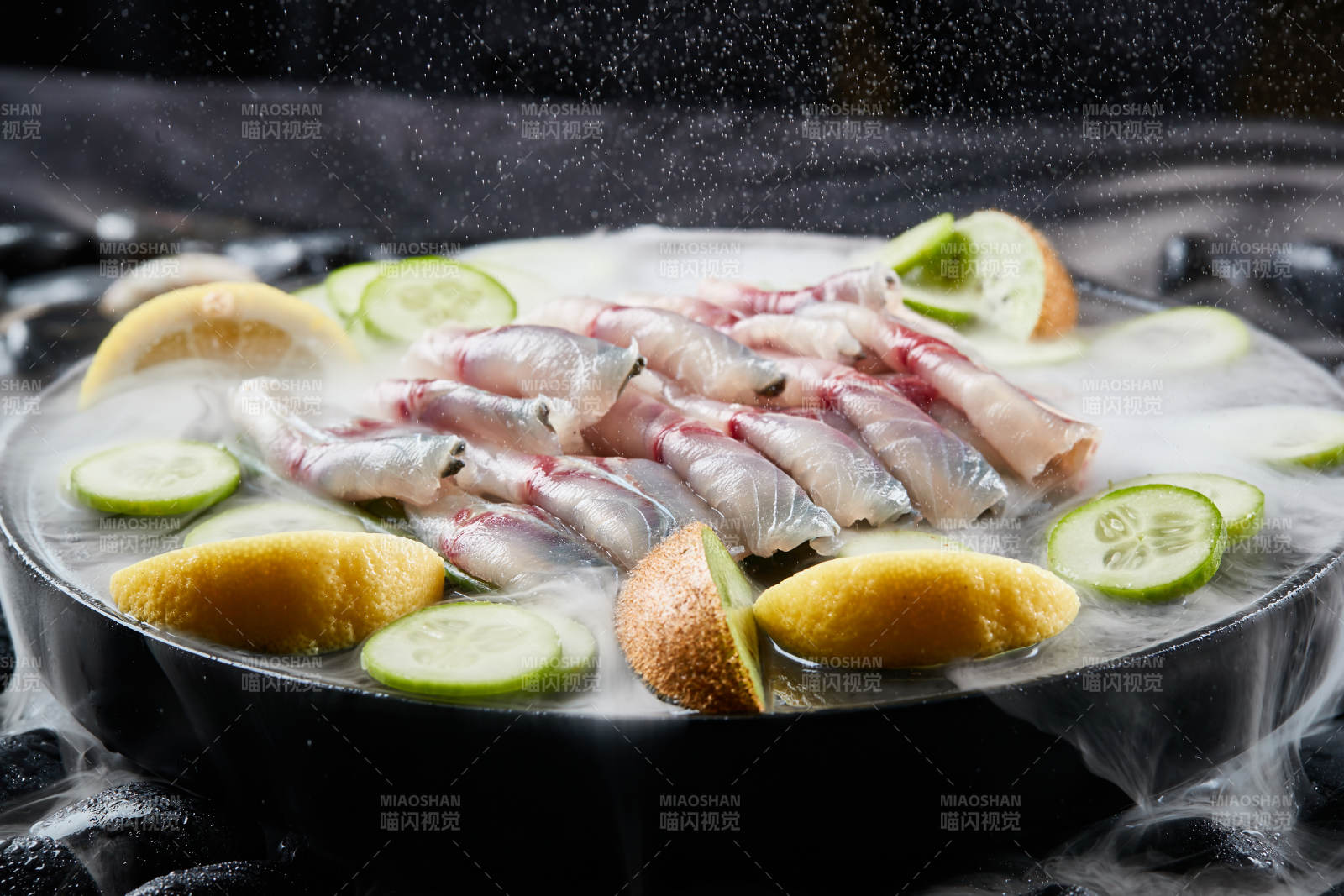 将晶莹白润的鲜鱼片码放在黑色的圆瓷盘上图片