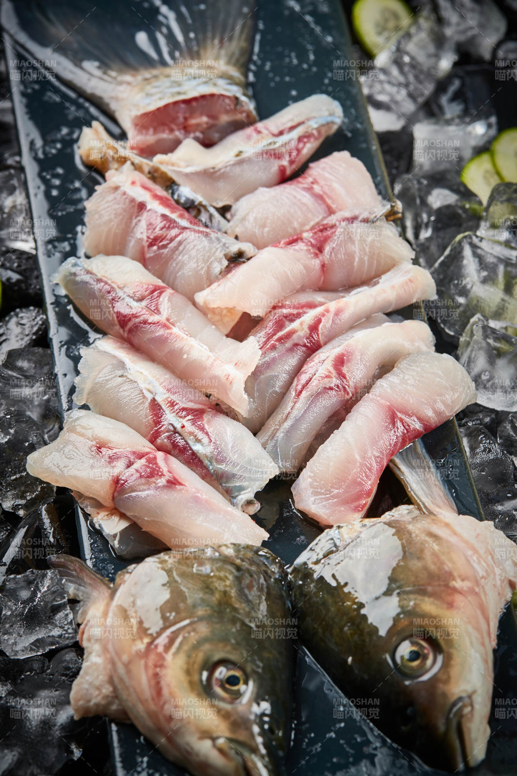 将晶莹白润的鲜鱼片码放在黑色的圆瓷盘上图片