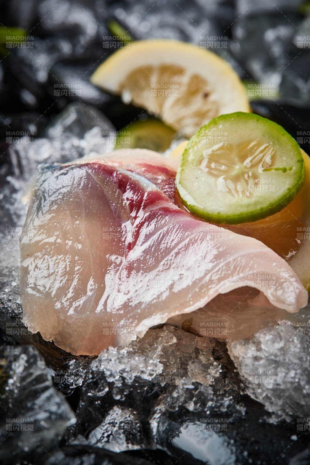 将晶莹白润的鲜鱼片码放在黑色的圆瓷盘上图片