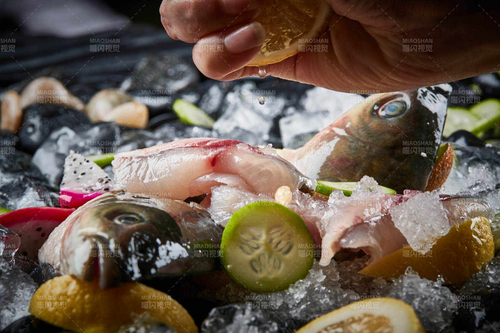 将晶莹白润的鲜鱼片码放在黑色的圆瓷盘上图片