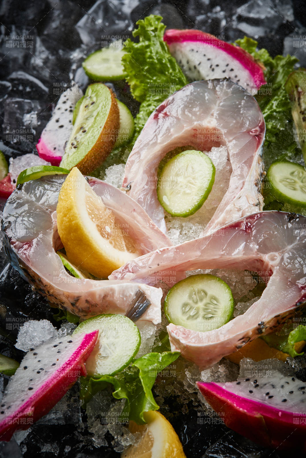 将晶莹白润的鲜鱼片码放在黑色的圆瓷盘上图片