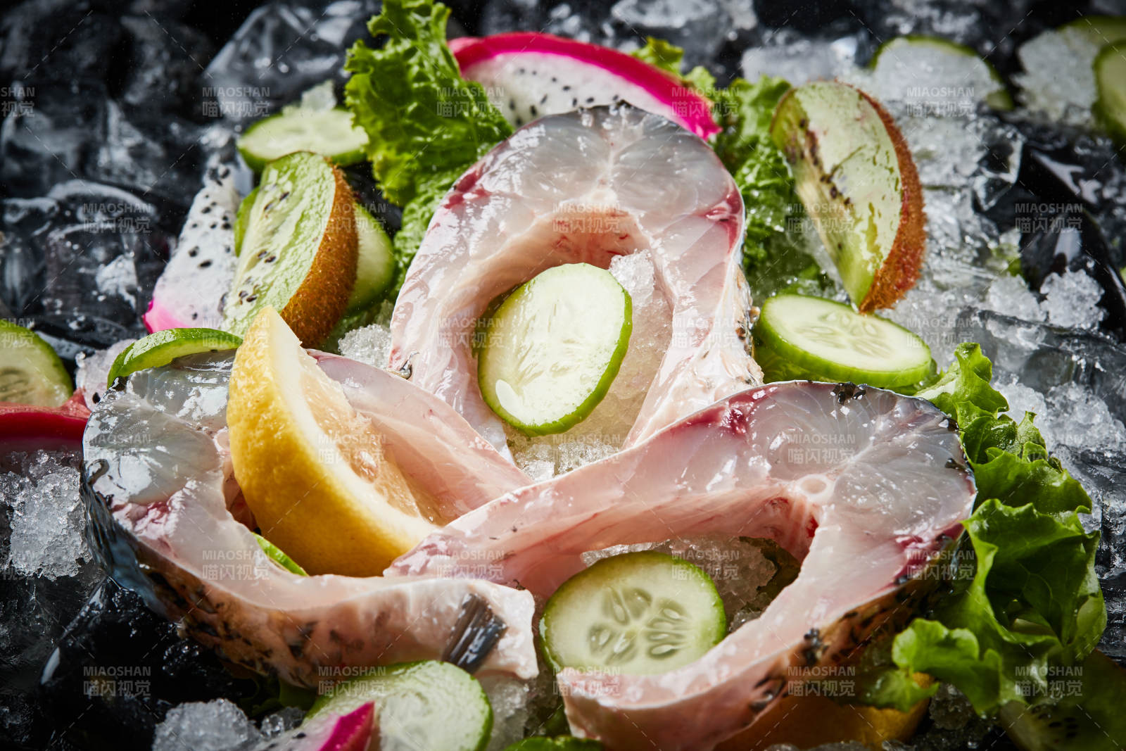 将晶莹白润的鲜鱼片码放在黑色的圆瓷盘上图片