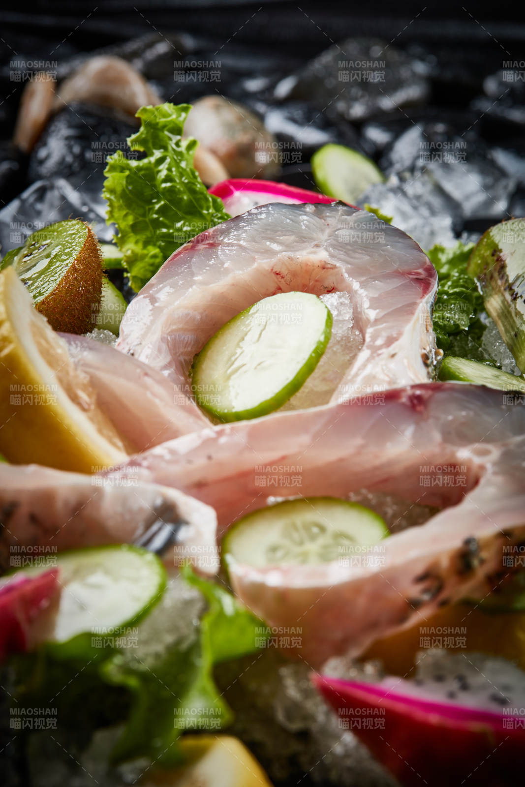 将晶莹白润的鲜鱼片码放在黑色的圆瓷盘上图片