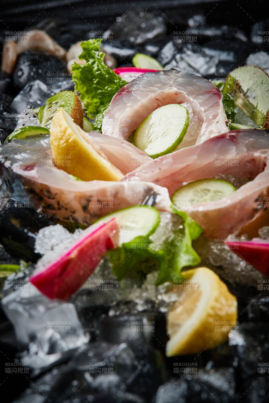 将晶莹白润的鲜鱼片码放在黑色的圆瓷盘上图片