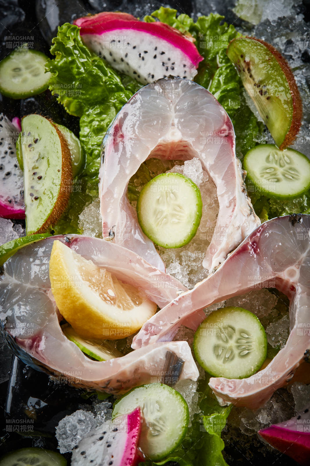 将晶莹白润的鲜鱼片码放在黑色的圆瓷盘上图片