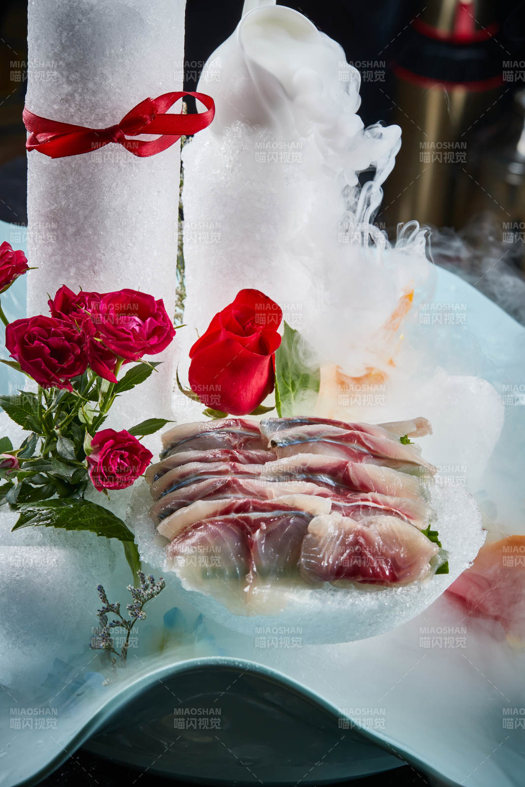 将晶莹白润的鲜鱼片码放在黑色的圆瓷盘上图片