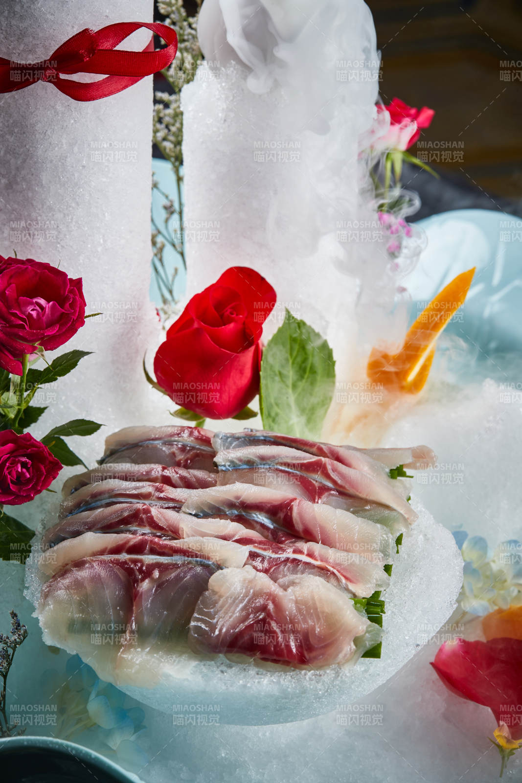 将晶莹白润的鲜鱼片码放在黑色的圆瓷盘上图片