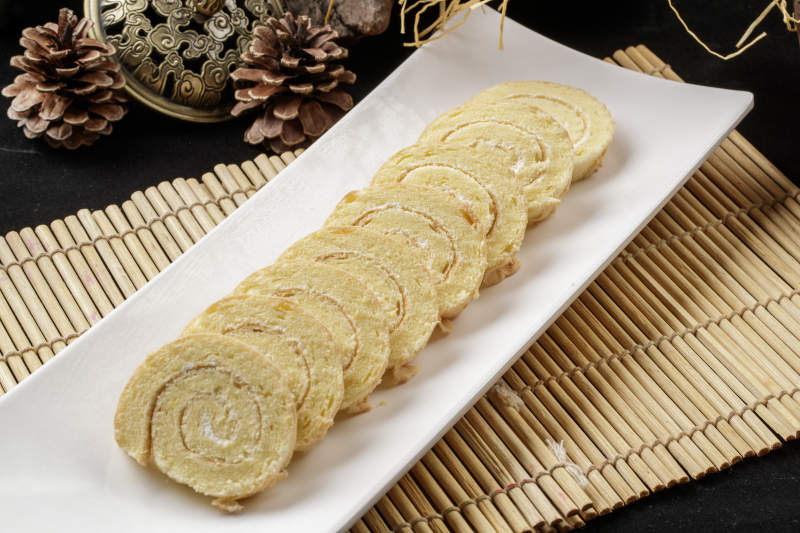 长瓷盘装的夹心奶油蛋糕卷图片