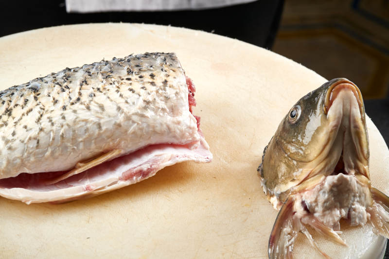 白色砧板上厨师用精湛的刀工展示生鱼片及鲜鱼料理切割分切的刀工图片