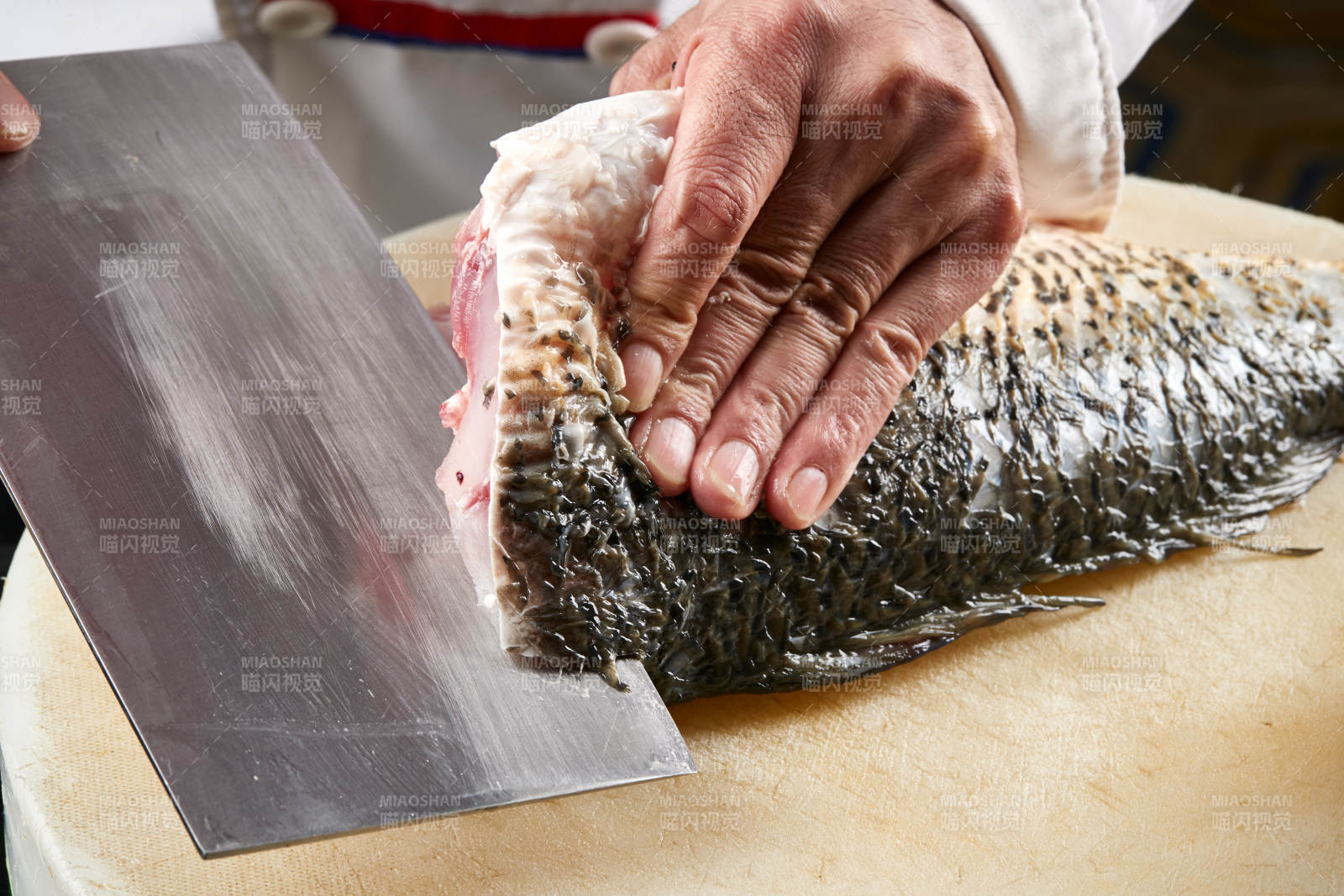 白色砧板上厨师用精湛的刀工展示生鱼片及鲜鱼料理切割分切的刀工图片