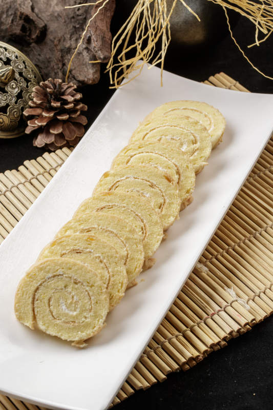 长瓷盘装的夹心奶油蛋糕卷图片