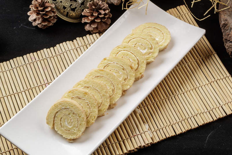 长瓷盘装的夹心奶油蛋糕卷图片