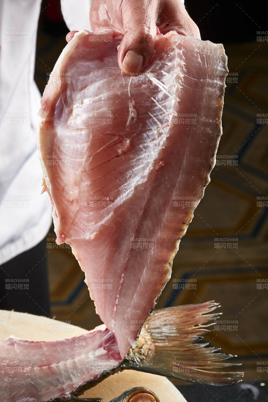 白色砧板上厨师用精湛的刀工展示生鱼片及鲜鱼料理切割分切的刀工图片