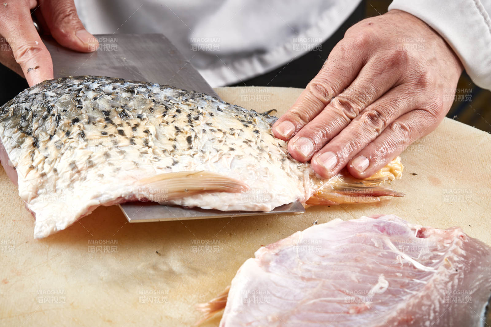 白色砧板上厨师用精湛的刀工展示生鱼片及鲜鱼料理切割分切的刀工图片