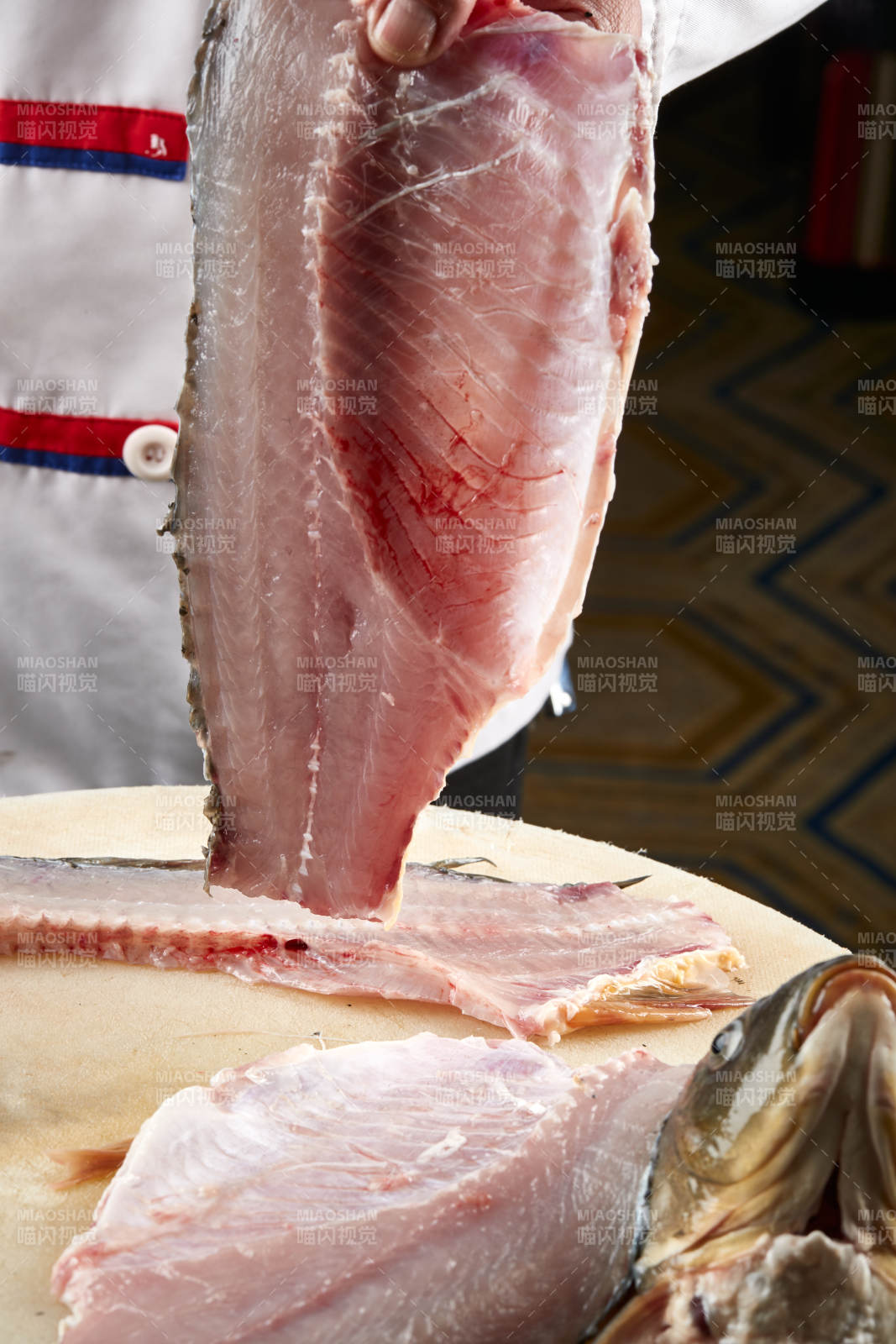 白色砧板上厨师用精湛的刀工展示生鱼片及鲜鱼料理切割分切的刀工图片