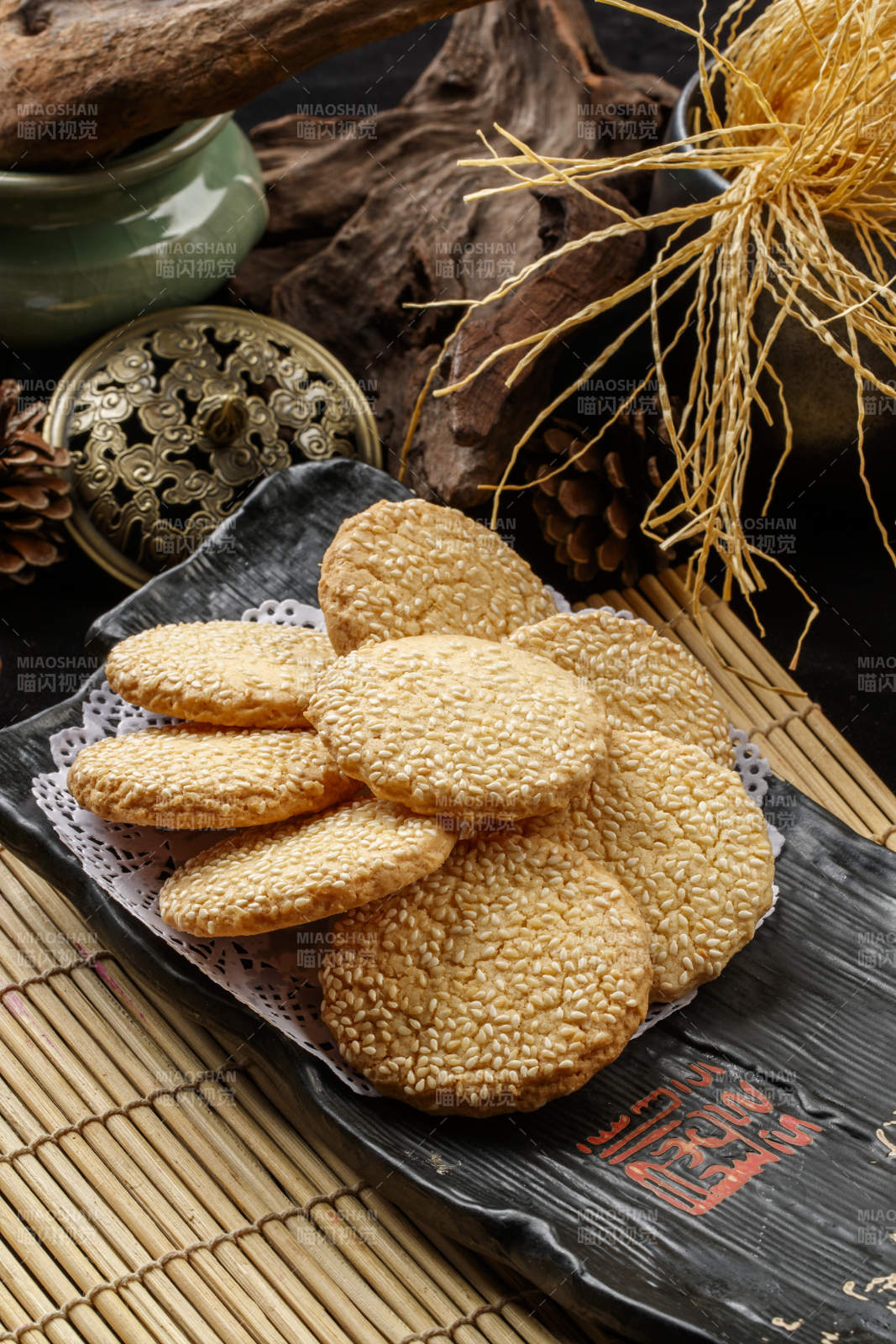 寿司帘上的黑磁盘装的芝麻烤饼图片