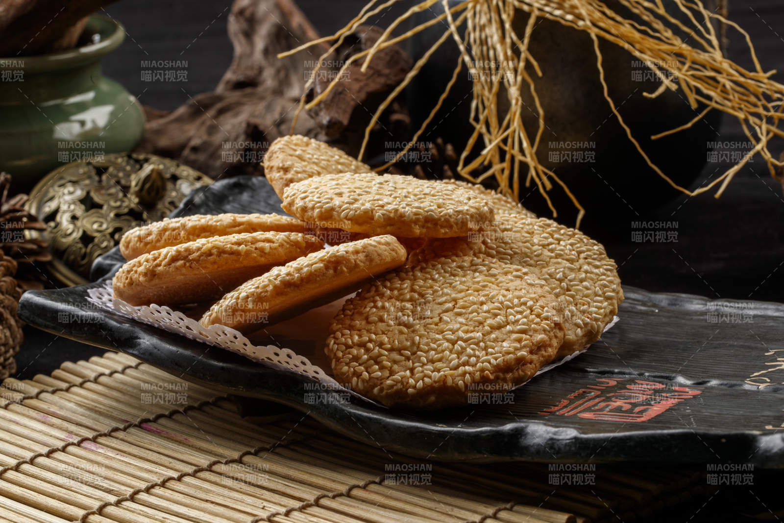 寿司帘上的黑磁盘装的芝麻烤饼图片