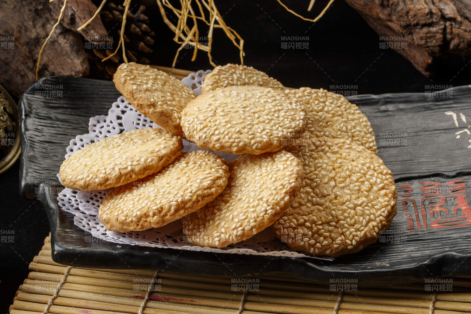 寿司帘上的黑磁盘装的芝麻烤饼图片