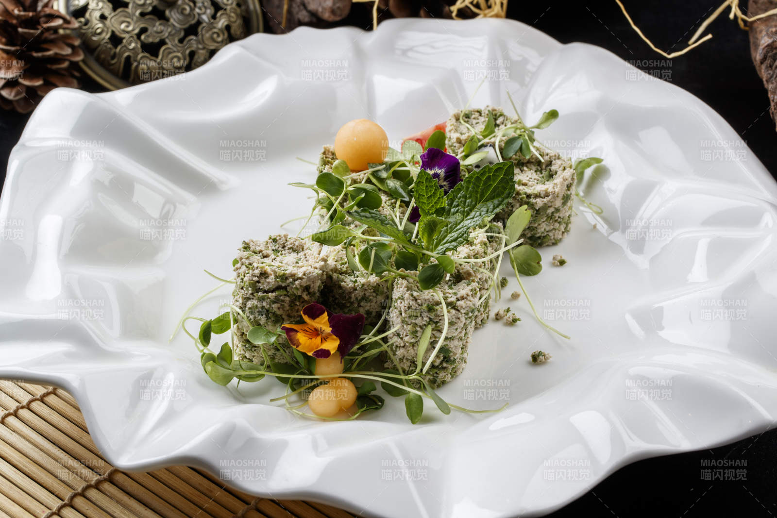 寿司帘上的花边瓷盘装的香椿苗麻豆腐图片