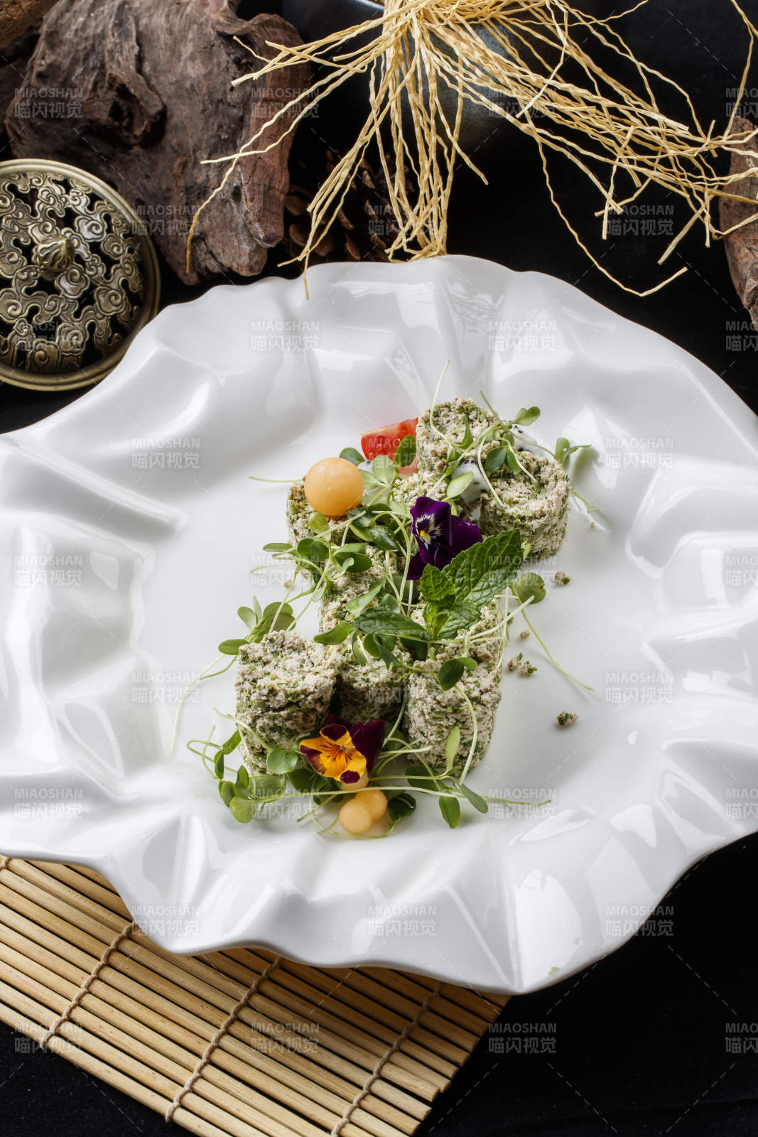 寿司帘上的花边瓷盘装的香椿苗麻豆腐图片