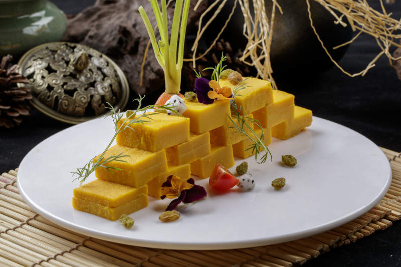 寿司帘上的圆瓷盘装的豌豆黄图片