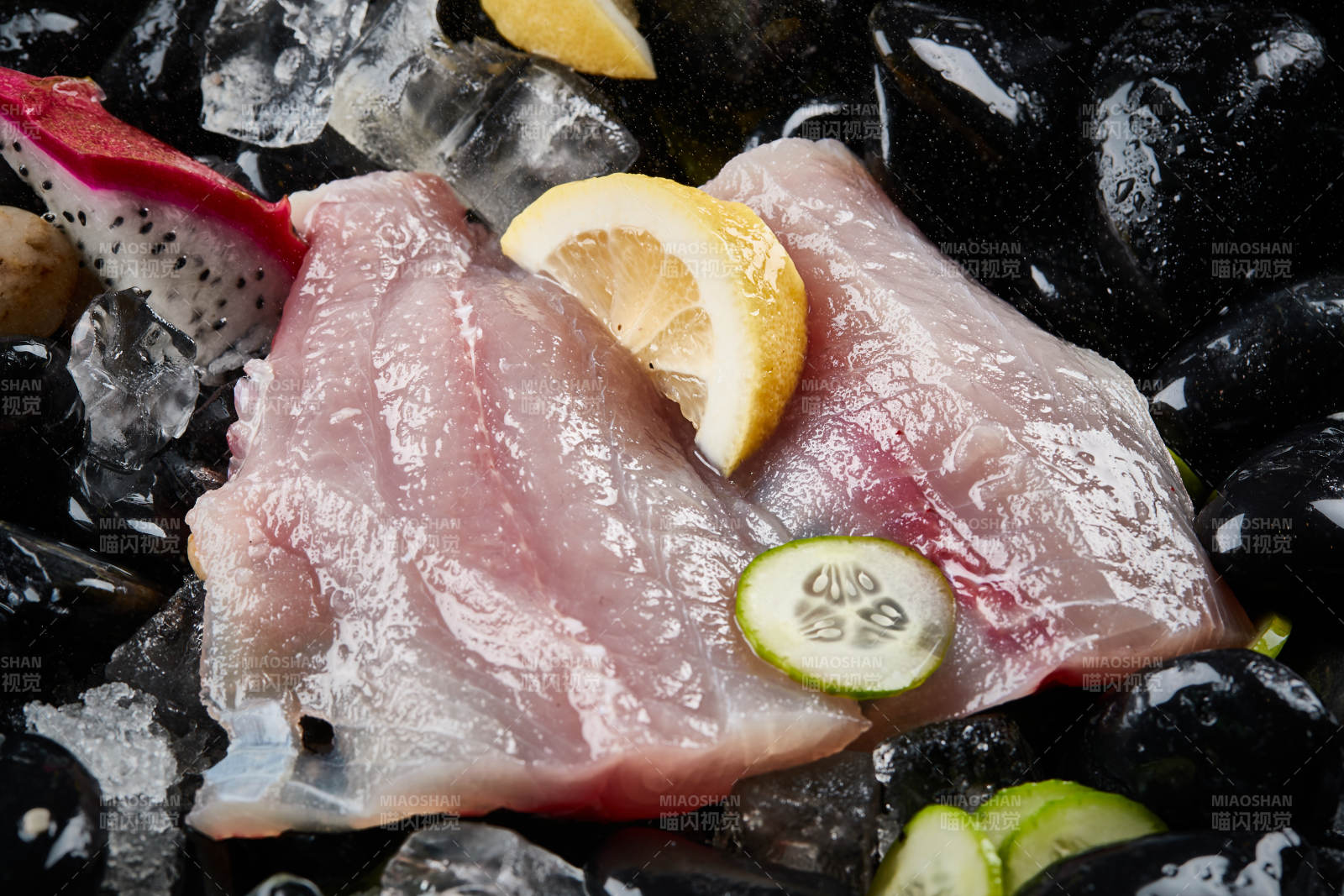 将晶莹白润的鲜鱼片码放在黑色的圆瓷盘上图片