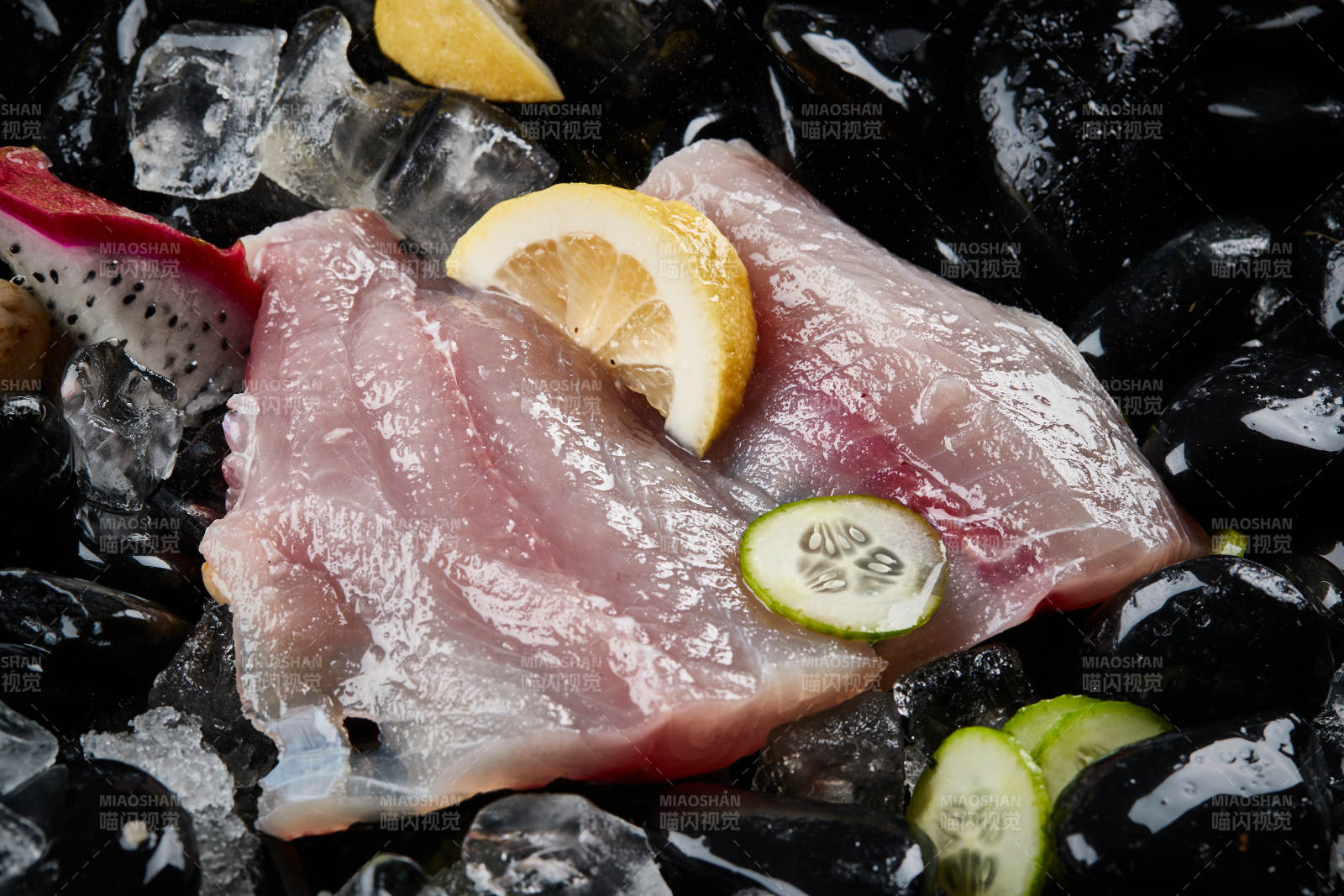 将晶莹白润的鲜鱼片码放在黑色的圆瓷盘上图片