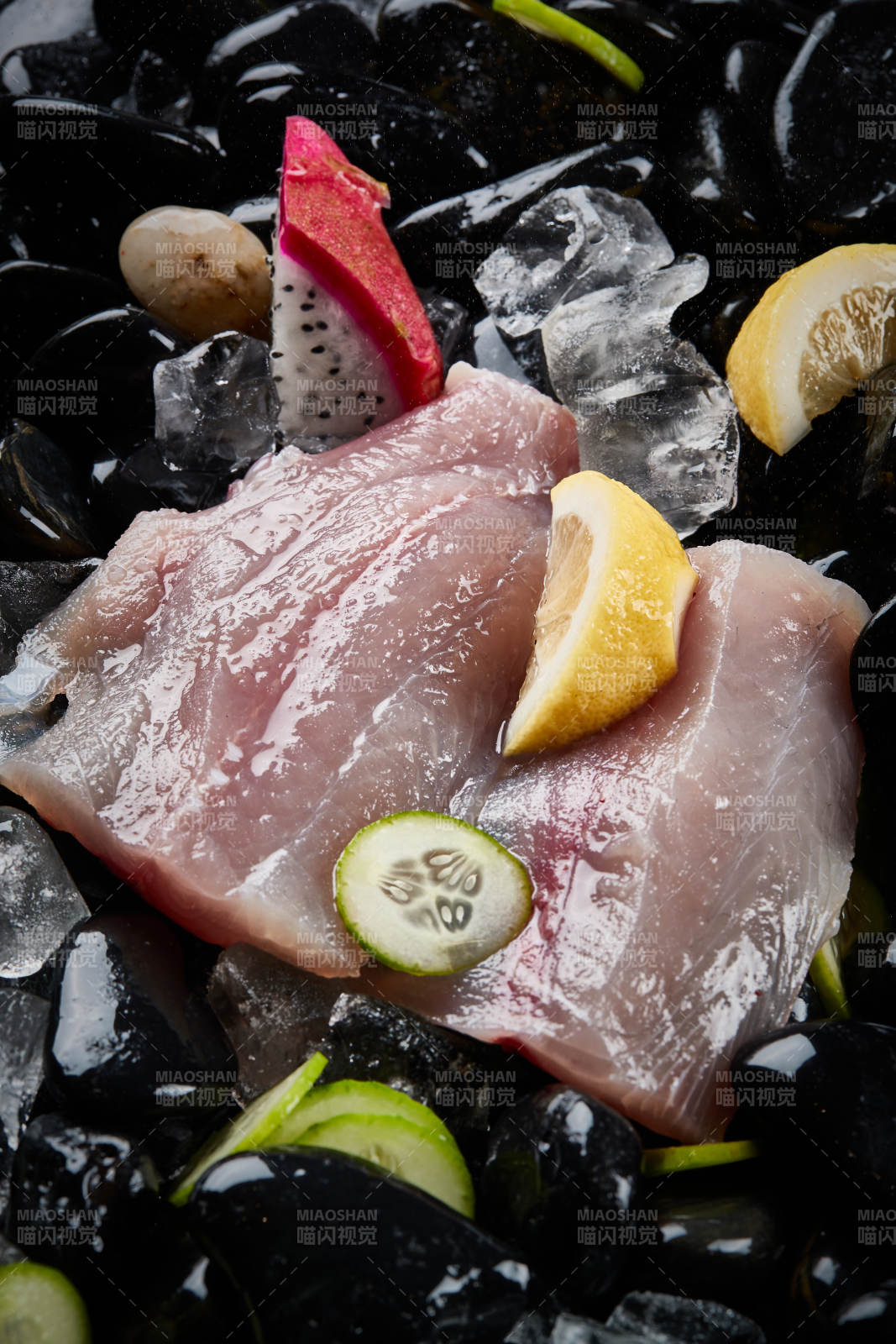 将晶莹白润的鲜鱼片码放在黑色的圆瓷盘上图片