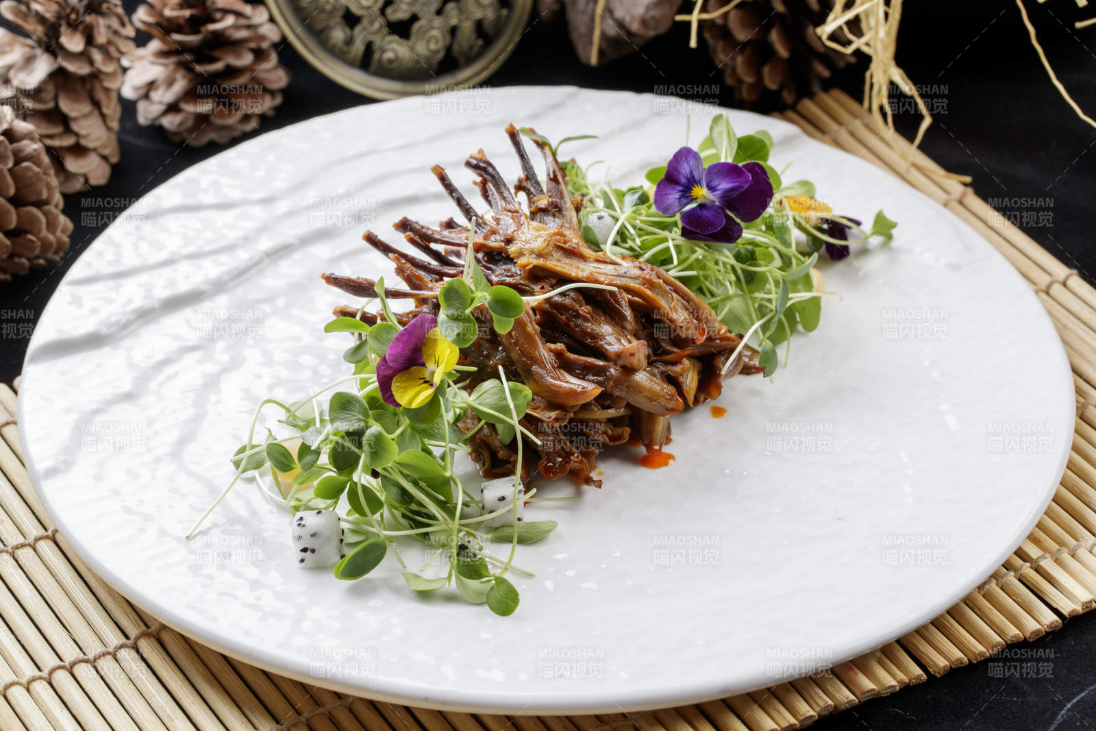 寿司帘上的圆瓷盘装的香辣鸭舌图片