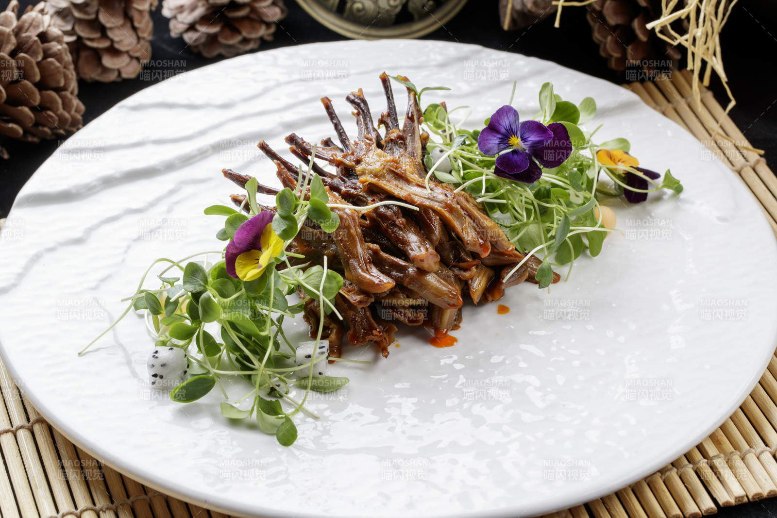 寿司帘上的圆瓷盘装的香辣鸭舌图片